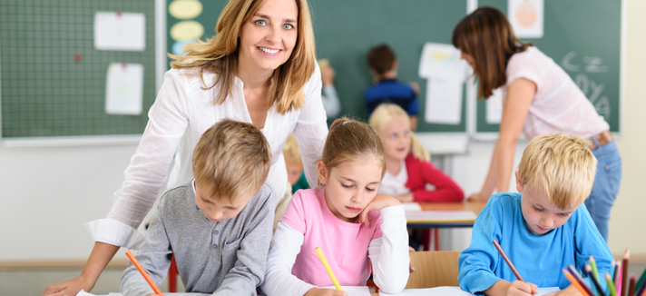 Freundliche Lehrerin mit Kindern in der Grundschule